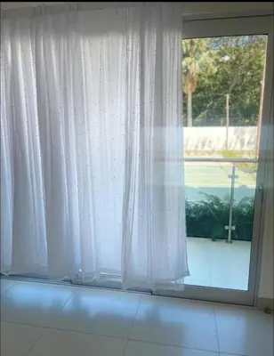 a window with white curtains in a room at Luxury first floor Apartment Pool kingside suite in Santiago de los Caballeros
