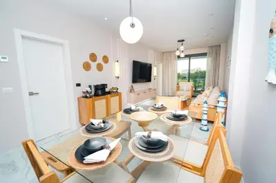 a living room with a table and chairs at Cana Rock Star D208 Jaccuzi Pool Golf and Private Beach in Punta Cana