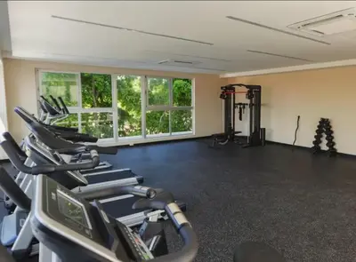 a gym with a row of treadmills and ellipticals at Juan Dolio RD Beach Retreat in Juan Dolio