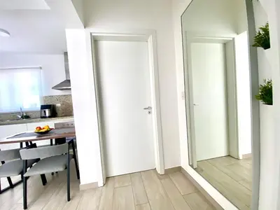 a kitchen with a table and a white door at Los corales 1Bedroom Apartament Close to the Beach Central los corales RD in Punta Cana