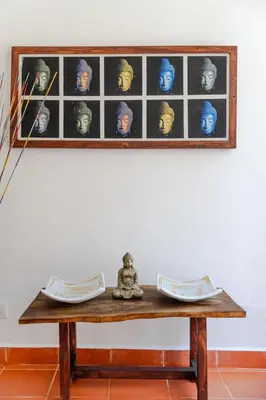 a table in front of a white wall with a picture at Bali Style Boutique Hotel in Las Terrenas