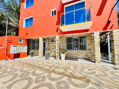a red building with a mosaic floor in front of it at Apartartamento cabarete in Cabarete