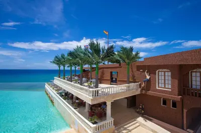 an aerial view of a building with palm trees and the ocean at Rheia Properties - SANTA FE in Sosúa