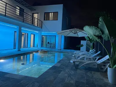 a swimming pool with two chairs and an umbrella at Apartamento Entre Playas 2- 3 pax, 4 min de la playa in Las Galeras