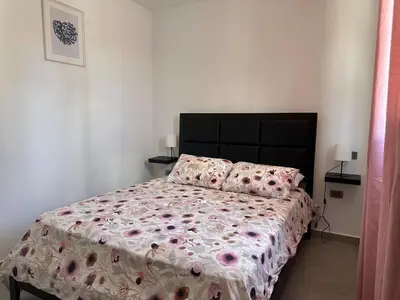 a bedroom with a bed with a floral bedspread and pillows at Apartamento Entre Playas 2- 3 pax, 4 min de la playa in Las Galeras
