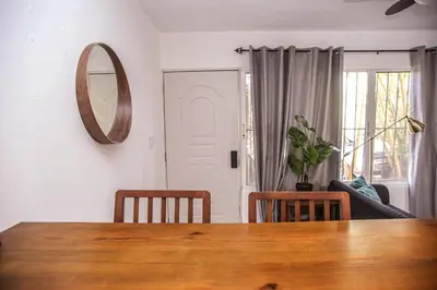 a dining room with a wooden table and a mirror at nNomad Apartment steps to Sirena - Apartment in Sosúa