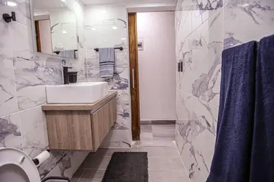 a bathroom with a sink and a toilet and a mirror at nNomad Apartment steps to Sirena - Apartment in Sosúa