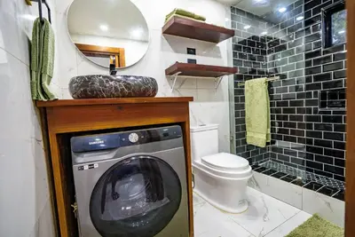 a bathroom with a washing machine and a toilet at nNomad Studio mins from Sirena - Apartment in Sosúa