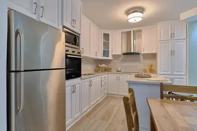 a kitchen with white cabinets and a stainless steel refrigerator at Costa Del Sol Juan Dolio 2BR Sunset, Beach Front in Juan Dolio