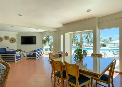 a dining room and living room with a table and chairs at Costa Del Sol Juan Dolio 2BR Sunset, Beach Front in Juan Dolio