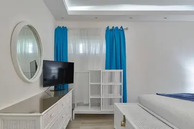 a bedroom with a bed and a mirror and a tv at Costa Del Sol Juan Dolio 2BR Sunset, Beach Front in Juan Dolio