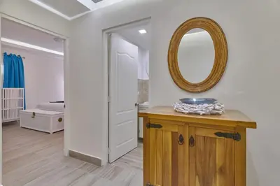 a bathroom with a mirror and a wooden table at Costa Del Sol Juan Dolio 2BR Sunset, Beach Front in Juan Dolio