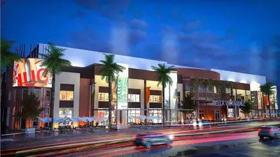 a building with palm trees in front of a street at Acogedor apartamento en Bella Vista, Casa Caribe in Santo Domingo