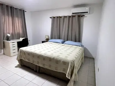 a bedroom with a bed and a desk and window at Acogedor apartamento en Bella Vista, Casa Caribe in Santo Domingo