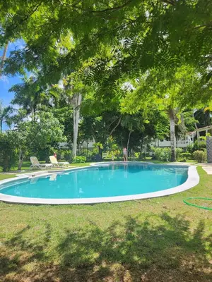 a person standing in a pool in a yard at KERY-OASIS 2bdr with pool close to the Beach in Las Terrenas