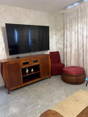a living room with a flat screen tv and a red chair at Villa con Piscina en la Romana in La Romana