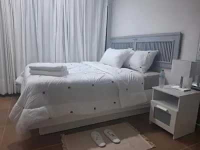 a bedroom with a bed with white sheets and pillows at Amazing condo in the hearth of Sosua PERFECT LOCATION in Sosúa