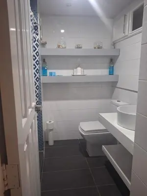 a white bathroom with a toilet and a sink at Amazing condo in the hearth of Sosua PERFECT LOCATION in Sosúa