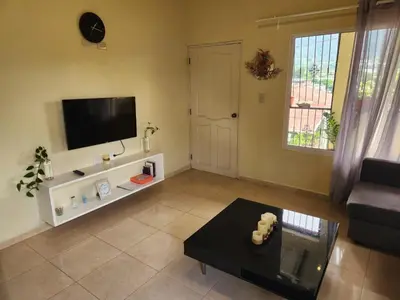 a living room with a couch and a tv at Remanso 1 in Jarabacoa