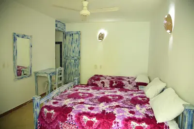 a bedroom with a bed with a purple comforter at Casa Brisa Mar Hotel in Las Terrenas