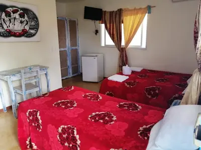 a bedroom with two beds and a red blanket at Casa Brisa Mar Hotel in Las Terrenas