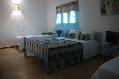 a bedroom with two beds and a television in it at Casa Brisa Mar Hotel in Las Terrenas
