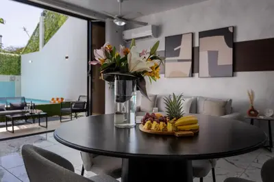 a table with a bowl of fruit and a vase of flowers at Perla 8- Exclusiva Moderna Villa 4 Habitaciones y Piscina in Sosúa