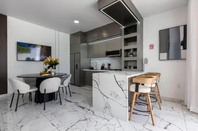 a kitchen and dining room with a table and chairs at Perla 8- Exclusiva Moderna Villa 4 Habitaciones y Piscina in Sosúa