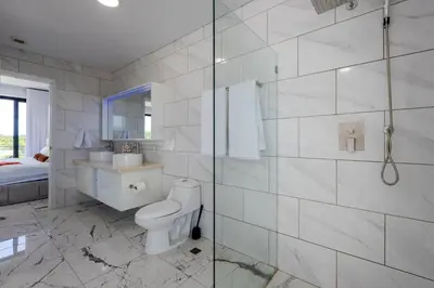 a white bathroom with a toilet and a shower at Perla 8- Exclusiva Moderna Villa 4 Habitaciones y Piscina in Sosúa