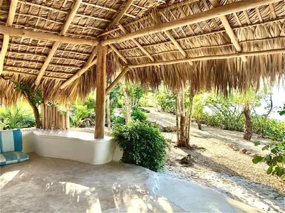 an outdoor pavilion with a tub under a straw roof at Ki-Ra Holistic Living in Boca de Chavón