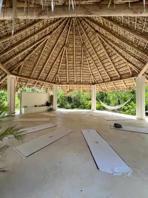 a large building with a thatched roof with tables at Ki-Ra Holistic Living in Boca de Chavón
