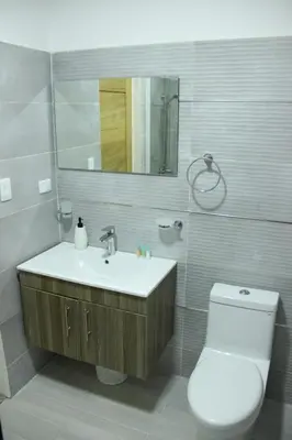 a bathroom with a sink and a toilet and a mirror at Acogedor y Moderno apartamento en Evaristo Morales in Colorado