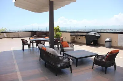 a patio with tables and chairs on a roof at Acogedor y Moderno apartamento en Evaristo Morales in Colorado