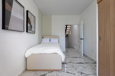 a white bedroom with a bed and a hallway at PERLA I -Modern Private Villa - 4 Bedrooms with Pool in Sosúa