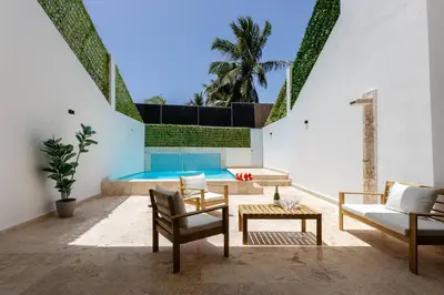 a patio with a pool and chairs and a table at PERLA I -Modern Private Villa - 4 Bedrooms with Pool in Sosúa