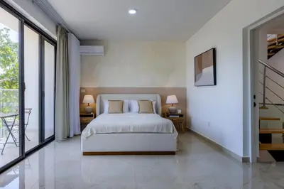 a bedroom with a bed and two tables with lamps at PERLA I -Modern Private Villa - 4 Bedrooms with Pool in Sosúa