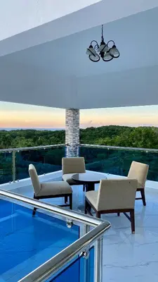 a room with chairs and a table on a balcony at Lujosa Villa in Río San Juan J in Río San Juan