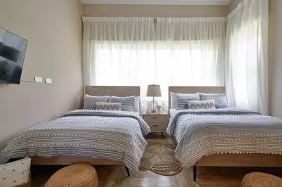 two beds in a bedroom with a window at ®{The~Beach~View} @PlayaBonita BeachfrontPool in Las Terrenas