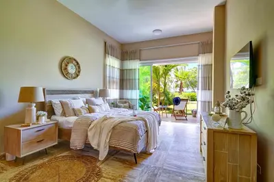 a bedroom with a bed and a table with a clock at ®{The~Beach~View} @PlayaBonita BeachfrontPool in Las Terrenas