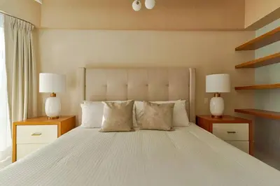 a bedroom with a large white bed with two lamps at Aquarella Caribbean Paradise Playa Juan Dolio in La Puntica de Juan Dolio