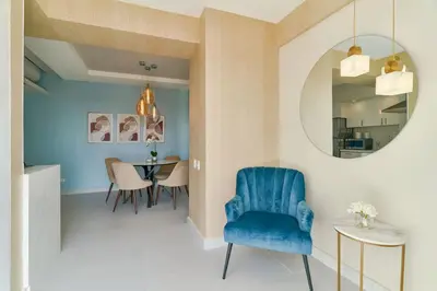 a dining room with a blue chair and a mirror at Aquarella Caribbean Paradise Playa Juan Dolio in La Puntica de Juan Dolio