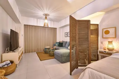 a bedroom with a couch and a tv in a room at Aquarella Deluxe Caribbean Paradise in La Puntica de Juan Dolio