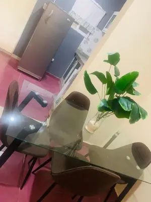 a glass table with two chairs and a potted plant at Apartamento Mariela 4 in San Felipe de Puerto Plata