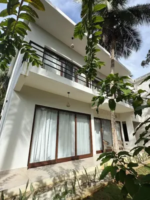 a white house with large windows and a palm tree at Casa Caona in El Valle