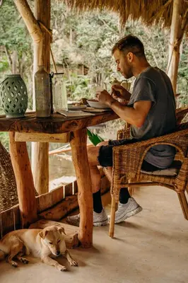 a man sitting at a table next to a dog at Casa Caona in El Valle