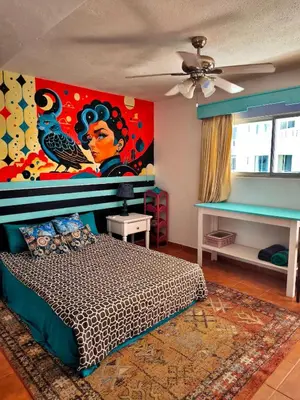 a bedroom with a bed with a painting on the wall at Chilvers Seaside Studio 202 in Cabarete