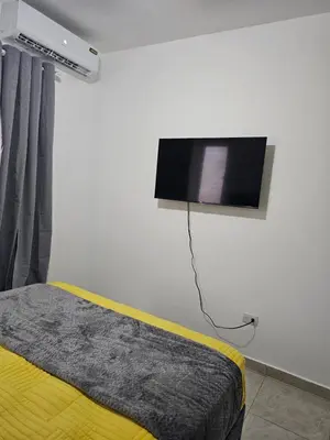 a bedroom with a bed and a tv on the wall at Modern 3BR Apmt Near Airport & Beach in San Isidro