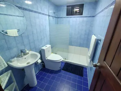 a blue tiled bathroom with a toilet and a sink at Céntrico y acogedor apartartamento con Wifi y Parqueo gratis in Santo Domingo
