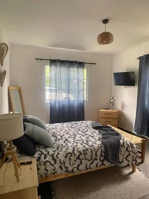 a bedroom with a bed and a window with blue curtains at Villa Linda in Polo