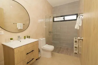 a bathroom with a toilet and a sink and a mirror at Cozy 1-BR Apartment in Sunshine Bayahibe in San Rafael del Yuma